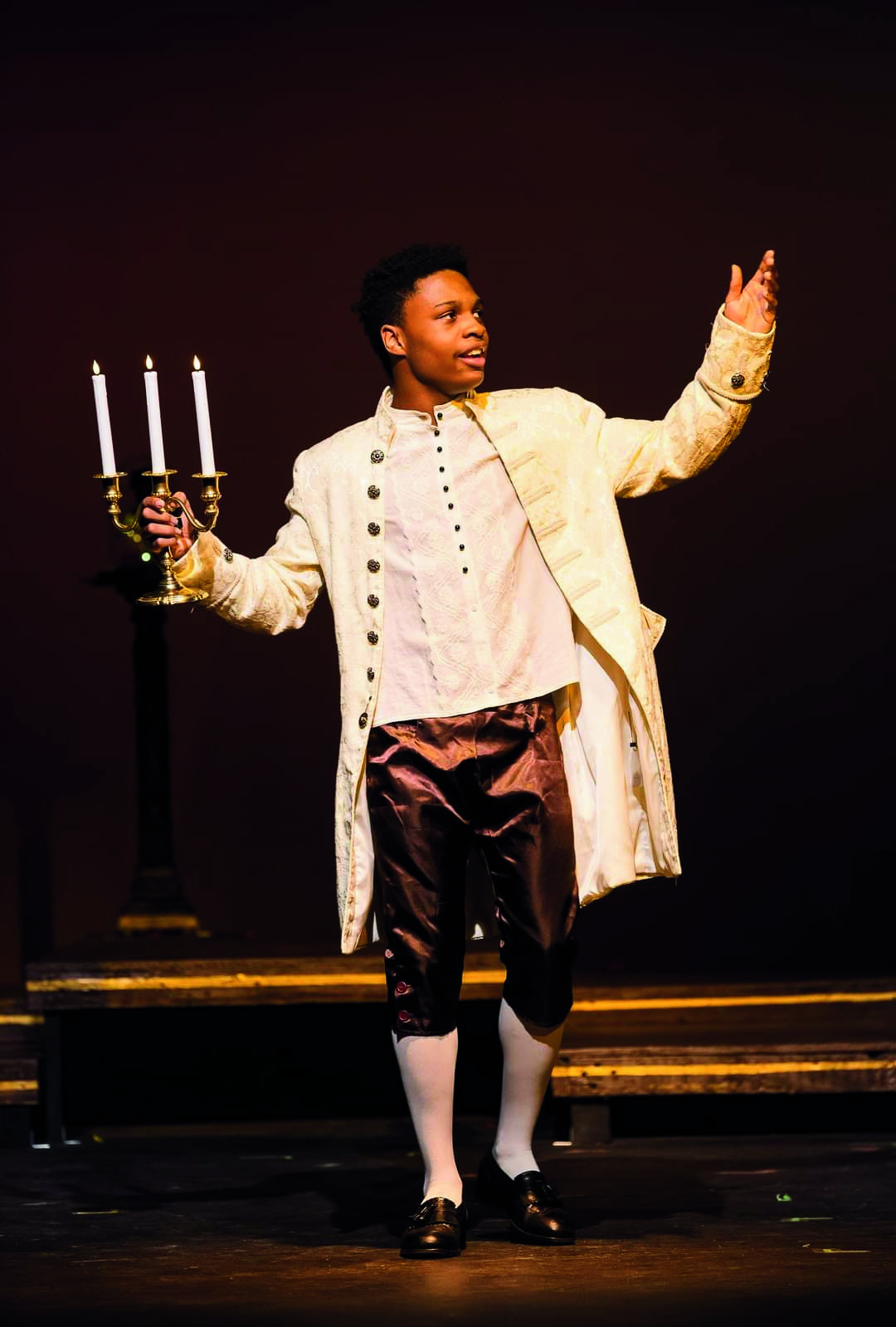 Lumiere performing on stage with candelabra